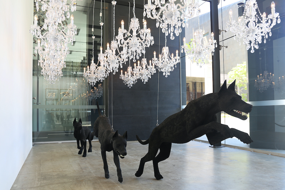 Abdul-Rahman Abdullah's work of  three black dog sculptures bounding through a gallery.