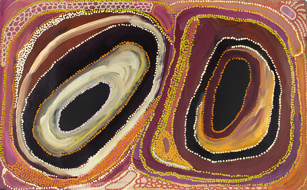 A traditional Aboriginal painiting, comprised of two sets of circles within circles, depicted in dots. The rings in between are different colours. The palette of the dots and rings is earthy colours - ochres - pinks, browns, yellows, oranges, creams.