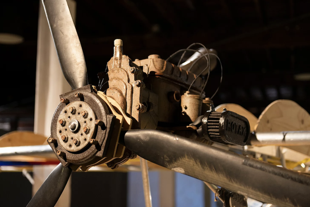 A close up of Amy Perejuan Capone's 'The plane dreamer'. We can see a ceramic propellor and the machinery behind it.
