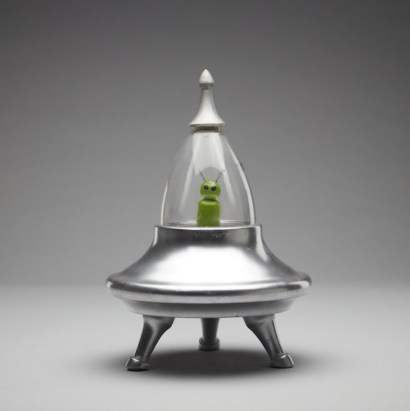 Pictured is an little green alien sitting within a metallic silver UFO for the Toy Stories Fringe World exhibition.