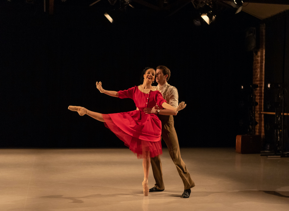 A pair of WA ballet dancers - he holds her waist, she holds her arms open as she extends one leg in front of her. She is smiling ecstatically.