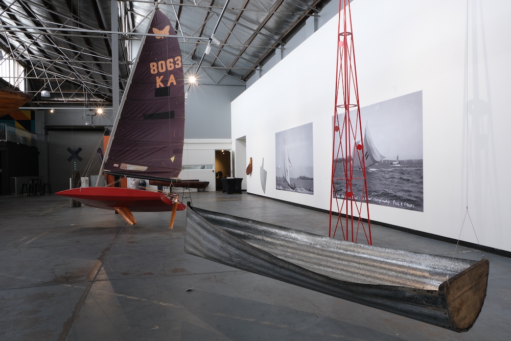 A sculpture from the 'Flying Circus' exhibition - pictured is a red sail boat and a metal dingy.
