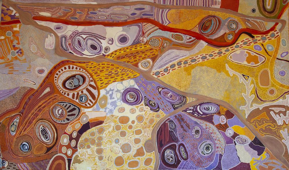 A painting based on traditional First Nations techniques, which looks like an aerial view of the landscape, depicted in ochres - oranges, yellows, reds and browns, but also purples.