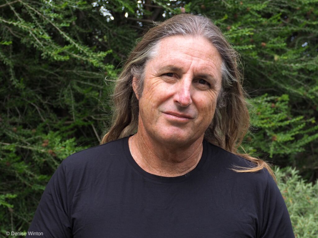 Portrait of man with long straight hair wearing black shirt