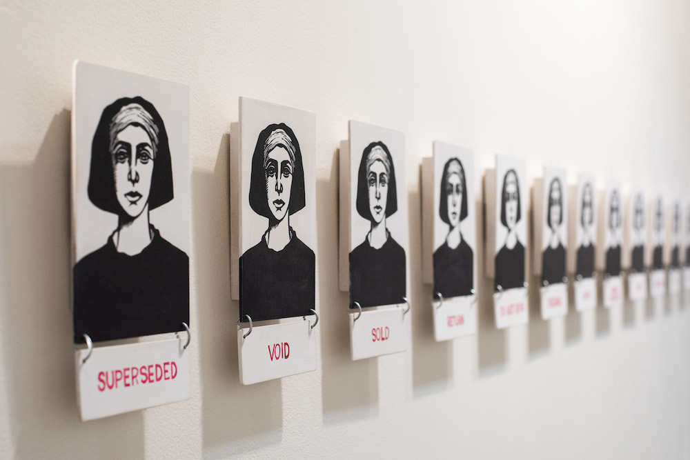 A series of printed images of a woman, in black ink on white background. Under each one is a caption in red capital letters - we can read the first three - superseded, void, sold -  the rest are out of focus.