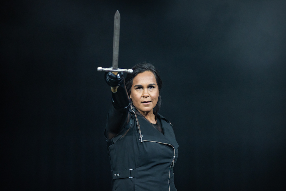 A scene from Frankenstein and the Lion of Nemea in which a woman dressed in a black zipper jacket and gloves holds forth a sword.