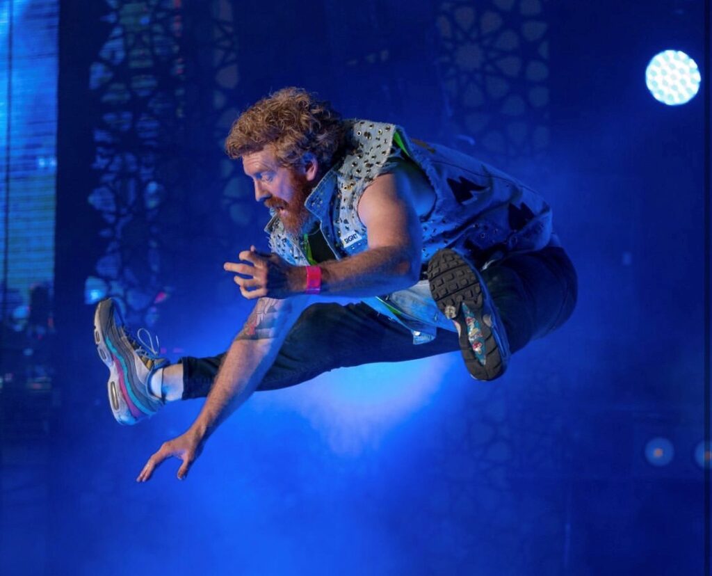 A bearded man dressed like an 80s rock act leaps into the air, arms posed as if holding a guitar. 
This is Alex 'Jinja Assassin' Roberts, national air guitar champion, who will be at the Air Guitar State Qualifiers for Fringe World.