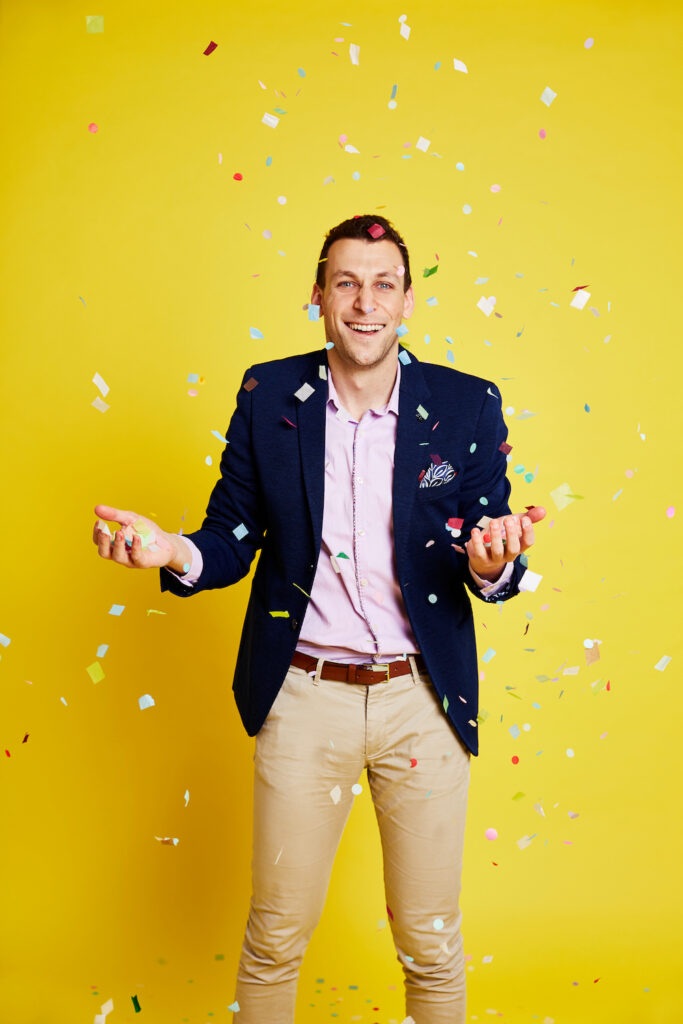 Michael Shafar stands with a smile on his face under falling confetti. 