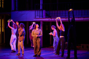 A scene from Seven Sisters showing young performers, holding cradles of fairy lights.
