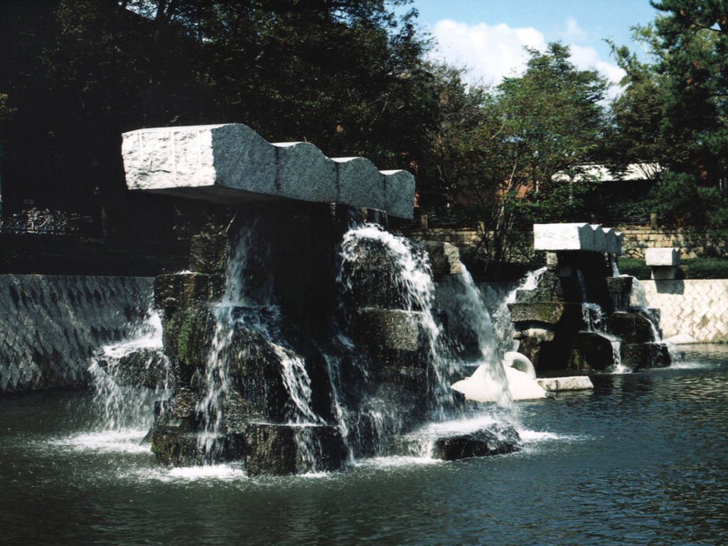 Waterdalls cascade from huge granite structures anchored in a pool of green water. This is Takeshi Tanabe's work dedicated to Handel's Water Music.