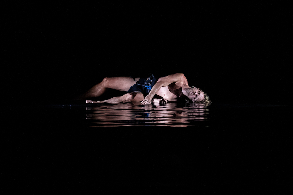 A man lies in a shallow pool of water in Laura Boynes' latest work.