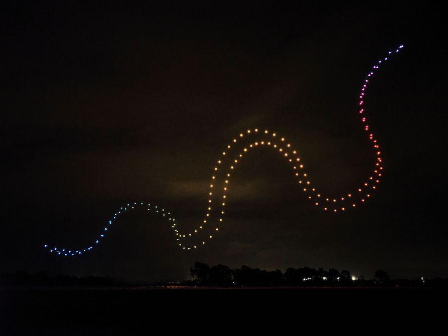 A snake-like trail of different coloured lights is emblazoned across the night sky. This is First Lights: Balarr Inyiny.